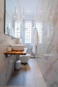 a white bathroom with a sink and a mirror at Oikia Classic House in Old Town Kavala in Kavala