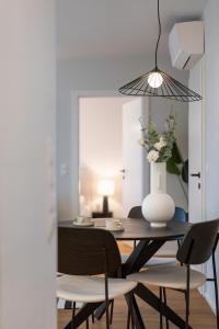 uma sala de jantar com uma mesa com um vaso de flores em Vienna Heights Premium Apartments em Viena