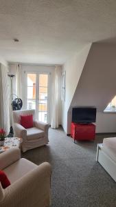 uma sala de estar com um sofá e uma televisão em Schwabenstuben Apartment em Meersburg