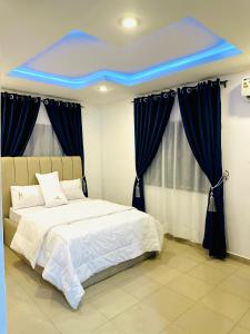 een slaapkamer met een bed met een blauw plafond bij D Governor's Place & Apartments in Port Harcourt