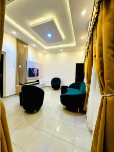 een wachtkamer met stoelen en een flatscreen-tv bij D Governor's Place & Apartments in Port Harcourt