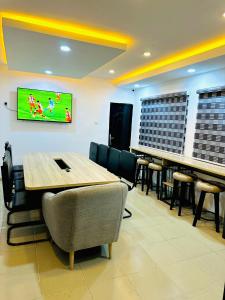 een vergaderzaal met een tafel en een tv aan de muur bij D Governor's Place & Apartments in Port Harcourt