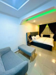 een slaapkamer met een bed, een bank en een stoel bij D Governor's Place & Apartments in Port Harcourt