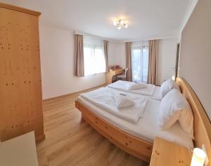 a bedroom with a large bed with white sheets at Haus Falle in Schiefling am See