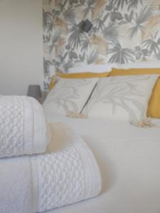 1 dormitorio con 2 camas, mantas blancas y almohadas en Le loft, en Landerneau