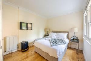 a bedroom with a bed and a television in it at Best Mayfair Location with 2 Super King Beds in London