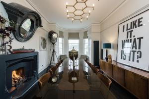 a living room with a fireplace and a table and chairs at The Residence in Kingskerswell