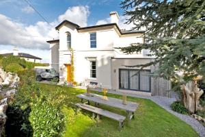 a white house with a picnic table in the yard at The Residence in Kingskerswell