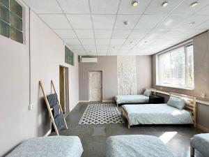 a hospital room with two beds and a window at Hostelis R27 in Aizpute