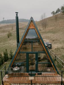 einem Pyramidenhaus mit Blick auf ein Feld in der Unterkunft Casuta Mea in Piatra Neamţ