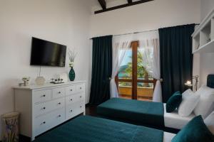 a bedroom with a bed and a dresser with a window at Villa Barotul with pool in Mrljane