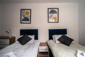 two beds sitting next to each other in a bedroom at England's Cozy 1-Bed room Room 1 in Manchester