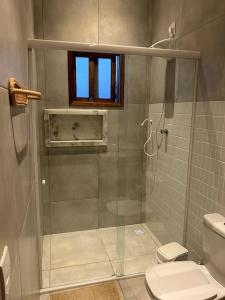 a bathroom with a shower with a toilet and a window at Paraíso à Beira-Mar, Touros RN - Acomoda 6 pessoas in Touros