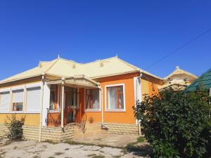 Maison jaune et orange avec terrasse couverte dans l'établissement SION In Ulmu, à Ulmu