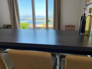 Una mesa negra con dos botellas de vino. en Apartman I & R en Nečujam