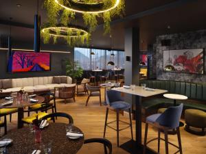 a restaurant with tables and chairs and a bar at Malmaison Manchester Deansgate in Manchester