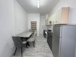 una piccola cucina con tavolo e frigorifero di Квартира a Türkistan