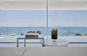 a living room with a table and a view of the ocean at OLYN VILLAS in Nikiti +61 photos