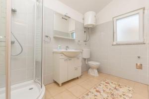 a bathroom with a sink and a toilet and a shower at Apartments Rosanda in Pirovac +46 photos