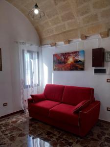 a red couch in a living room with a painting at SA' GRAVIN in Castellaneta