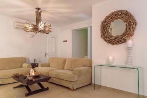 ein Wohnzimmer mit einem Sofa, einem Tisch und einem Spiegel in der Unterkunft Villa Sevil in Lachania