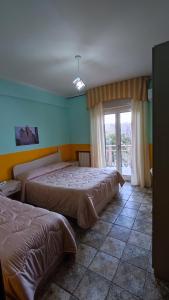 1 Schlafzimmer mit 2 Betten und einem Fenster in der Unterkunft Hotel San Francesco Terme in Spezzano Albanese