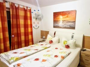 Dos camas en una habitación de hotel con flores. en Hotel Garni Rodenbach, en Rodenbach