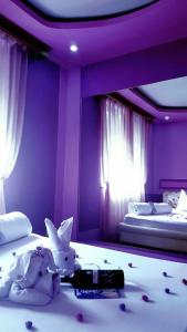 - une chambre avec 2 lits aux murs violets dans l'établissement Apartman Sekulić, à Doboj