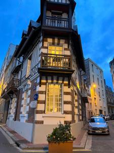 un grand bâtiment avec un balcon dans une rue dans l'établissement L emeraude - Trouville, à Trouville-sur-Mer