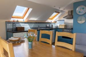 a kitchen with a wooden table and chairs at Delfryn Holiday Cottages in Solva