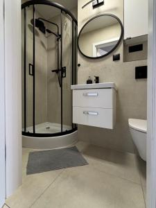 een badkamer met een douche, een wastafel en een spiegel bij Healthy Life Apartment in Warschau
