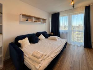 een groot bed in een kamer met een groot raam bij Healthy Life Apartment in Warschau