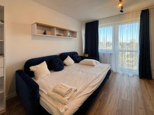 a large bed in a room with a large window at Healthy Life Apartment in Warsaw
