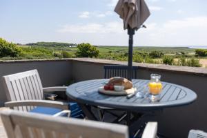 a table with a plate of food and an umbrella at Delfryn Holiday Cottages in Solva +19 photos