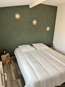 a bedroom with a white bed with two lights on the wall at Appartement à Mailly-le-camp in Mailly-le-Camp