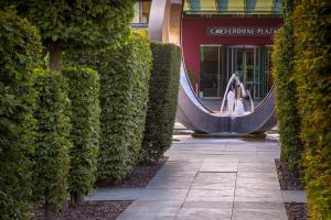 Una donna è in piedi di fronte a un palazzo di Crowne Plaza Marlow, an IHG Hotel a Marlow