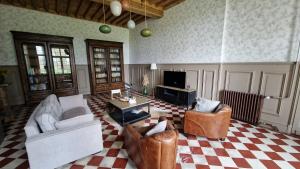 a living room with two chairs and a tv at La Maison du Séguy in Saint-Ciers-de-Canesse