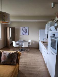 a kitchen and dining room with a table and white appliances at Apartmán Greenside in Michalovce