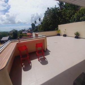 宿霧市的住宿－Eli's Villa Cebu，两把红色椅子坐在建筑物的屋顶上