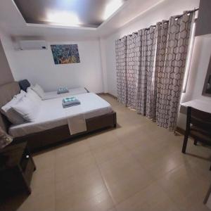 ein Schlafzimmer mit einem Bett und Vorhängen in einem Zimmer in der Unterkunft Eli's Villa Cebu in Cebu City