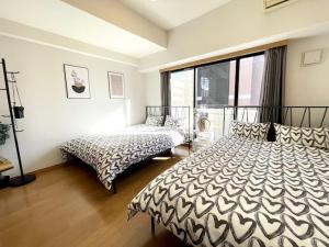 1 dormitorio con 2 camas y ventana grande en S2 Shibuya House 850m from Shibuya Sta en Tokio