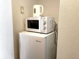 a microwave sitting on top of a refrigerator at S2 Shibuya House 850m from Shibuya Sta in Tokyo