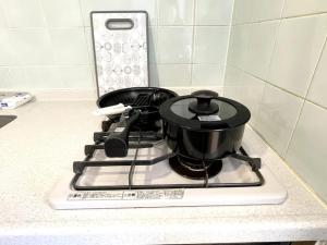 a pot sitting on top of a stove at S2 Shibuya House 850m from Shibuya Sta in Tokyo +30 photos