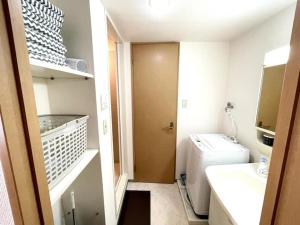 a small bathroom with a sink and a washer and dryer at S2 Shibuya House 850m from Shibuya Sta in Tokyo