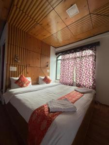 a bedroom with two beds and a window at Hotel Rangyul in Kargil