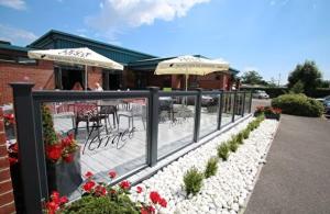 a restaurant with a patio with tables and umbrellas at narcissus in Ferndown