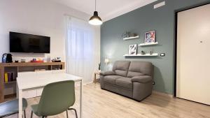 uma sala de estar com um sofá, uma mesa e uma cadeira em Casa Bolina - Mini appartamento em Taranto