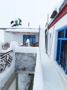 a snow covered hallway of a building with blue doors at Nawang HomeStay in Kaza