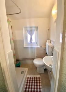 uma casa de banho com um WC, um lavatório e uma janela em Maison Sarraj Affittacamere em Parma