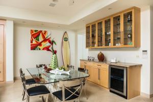 a dining room with a glass table and a surfboard at Kove Villa in Honolulu